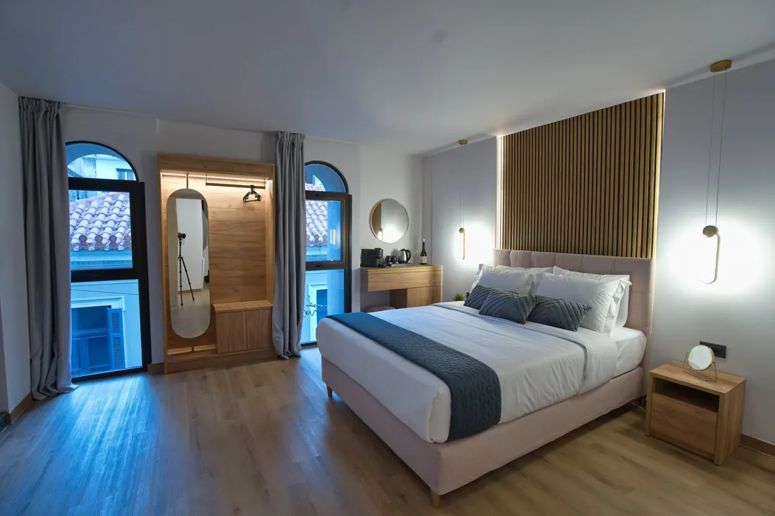 A Premium room with a wooden headboard and arched windows