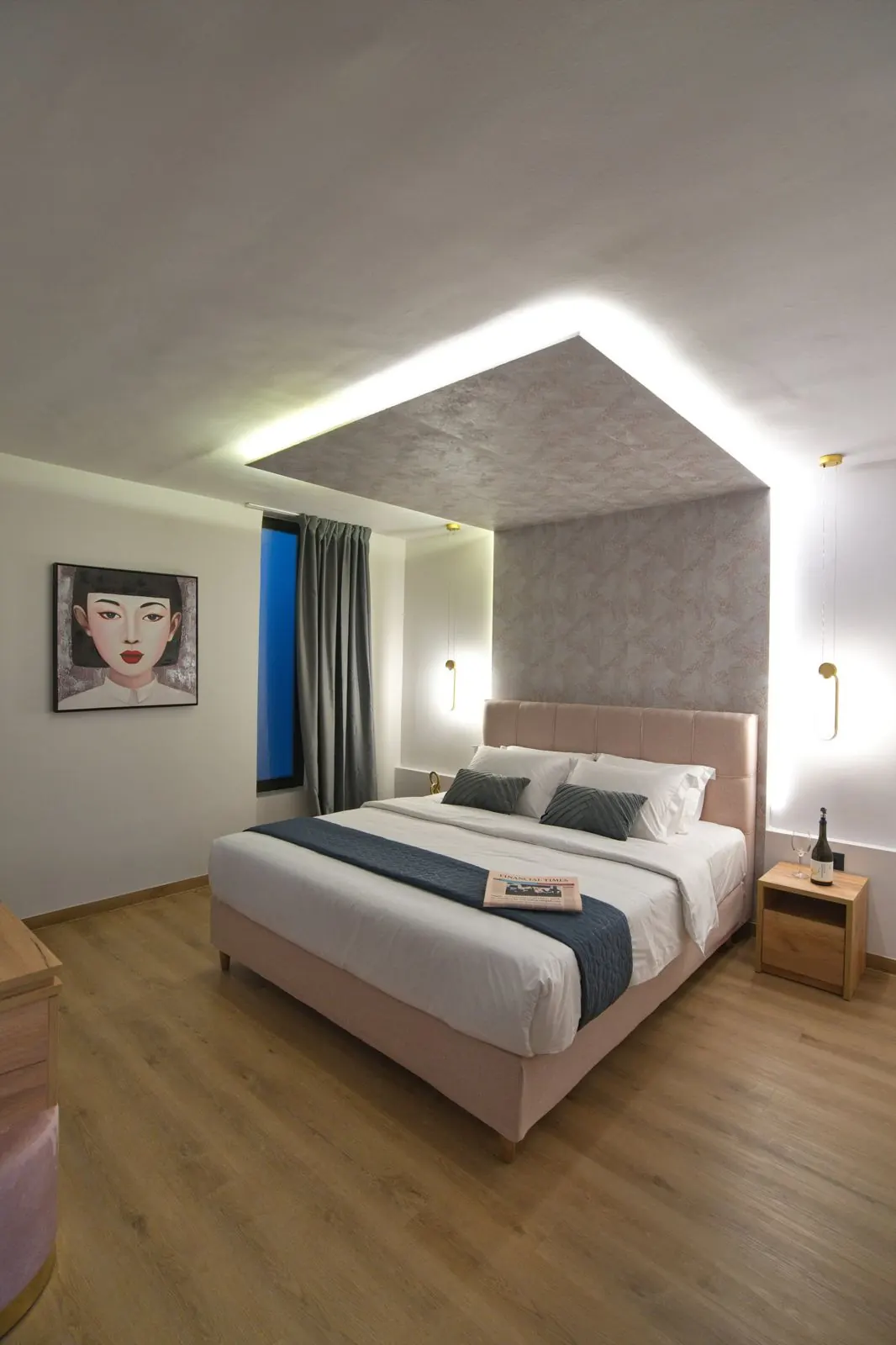 A bedroom with a pink headboard and a lit ceiling